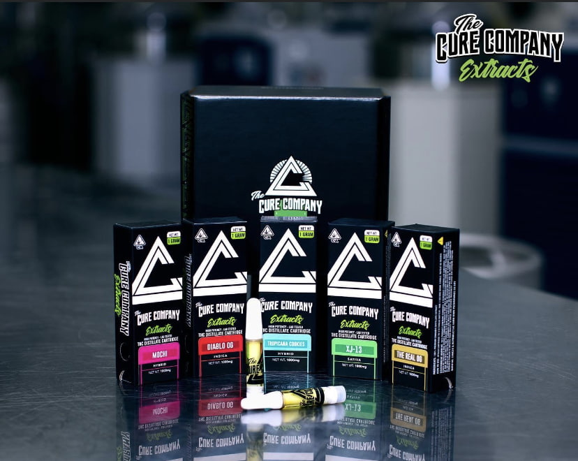 Cure company vaporizer cartridges in front of cure company packaging