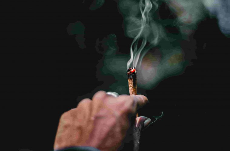Hand holding cannabis joint during Covid-19