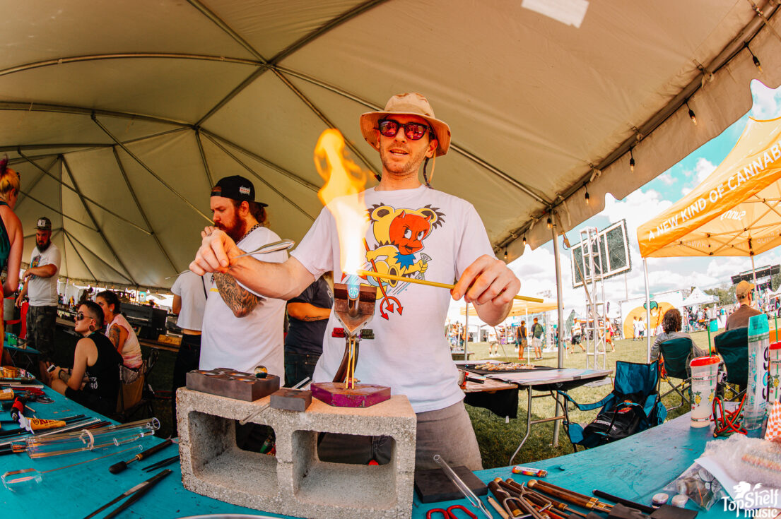 an artist blowing glass at Florida Groves festival